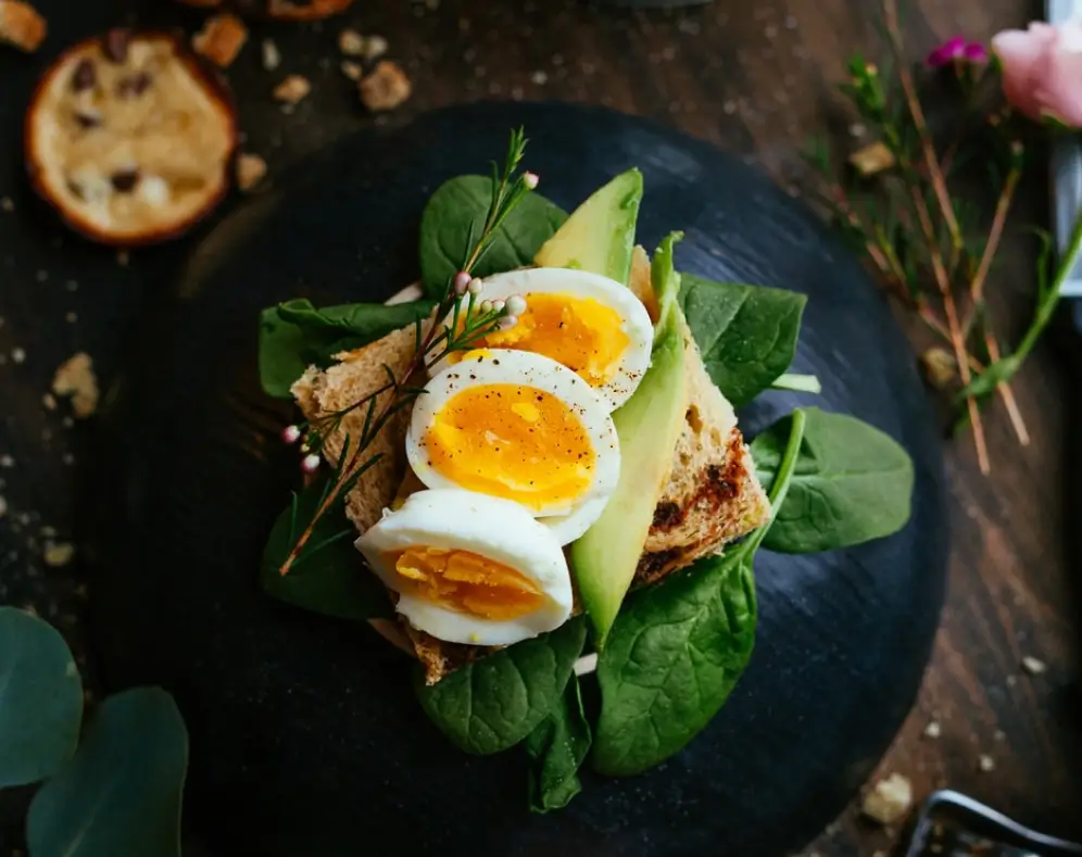Boiled eggs on spinach and toast with herbs.