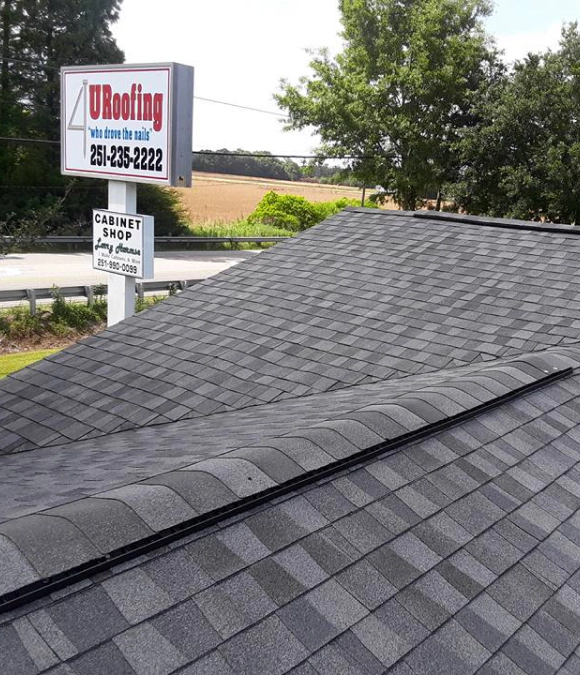 Newly installed dark asphalt shingle roof with clear ridges.